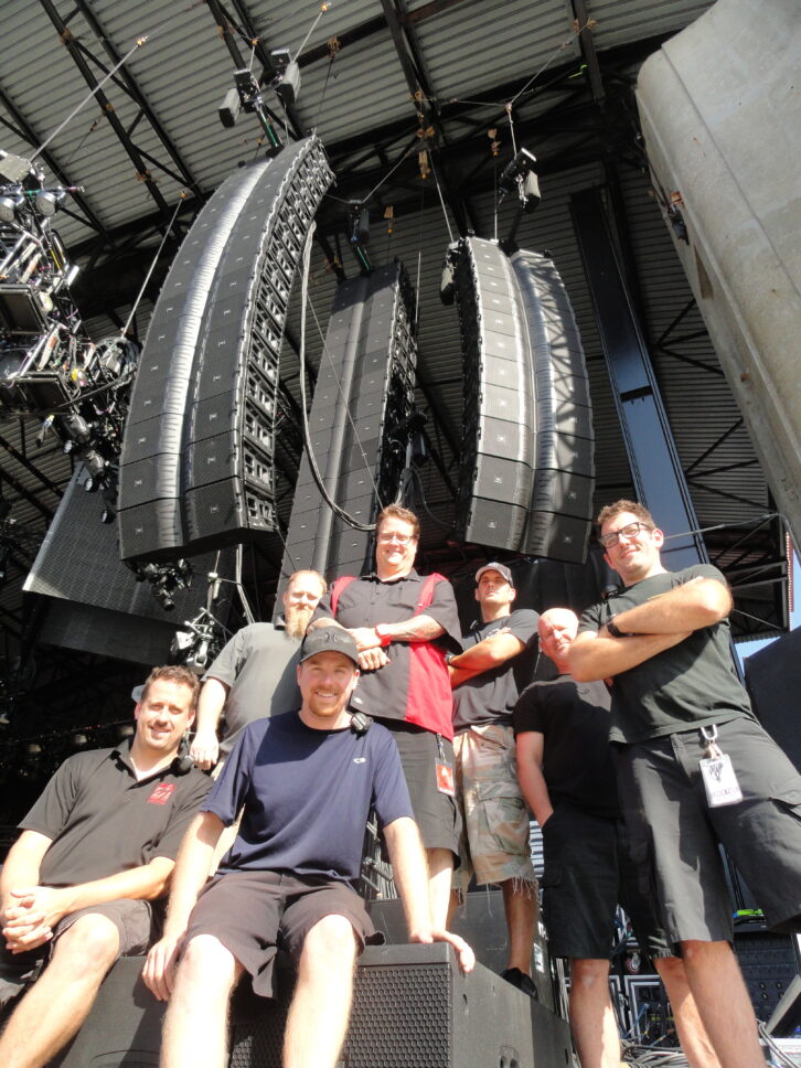 Beneath the massive JBL VTX system provided by Sound Image is the Linkin Park audio team (Back Row, l-r): Kevin “Tater” McCarthy, monitor engineer; Ken “Pooch” Van Druten, FOH engineer; Scott Taylor, PA tech; John Leary, crew chief; Vic Wagner, systems engineer. (Front Row, l-r): Paul White, monitor tech/RF; Nathan Payne, PA tech.