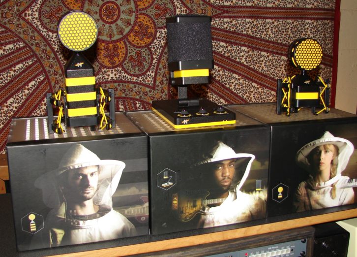 The unmistakable stylings of newcomer brand Neat Microphones; left to right, King Bee, Beecaster and Worker Bee models sit atop their stylized packaging.
