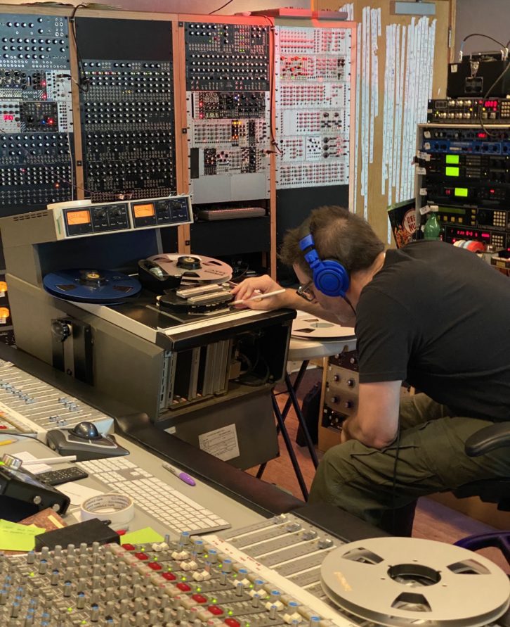 Engineer Ryan Hewitt leaning over to adjust the Ampex ATR-102.