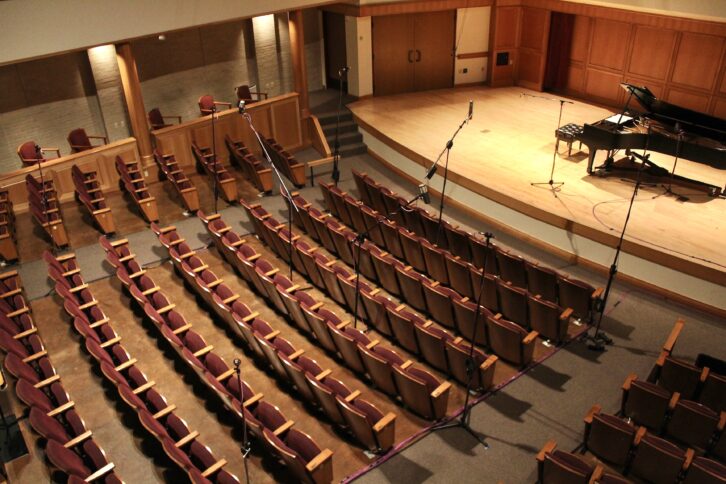 Evergroove assistant engineer Athena Wilkinson set up an immersive miking array in the seating area of the auditorium at the Lamont School of Music at the University of Denver to record Igor Pikayzen, an award-winning Russian-American violinist, for an immersive release. PHOTO: Athena Wilkinson