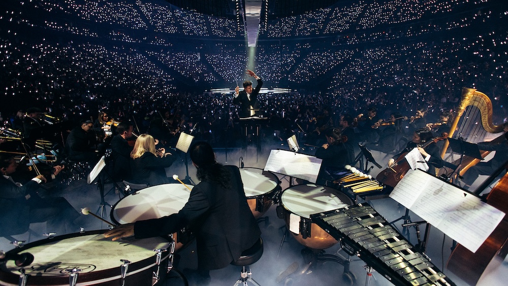 Carlitos Lopez conducted the Philharmonic Orchestra Project nightly on Bad Bunny’s recent in-the-round arena tour. Photo: Eric Rojas.