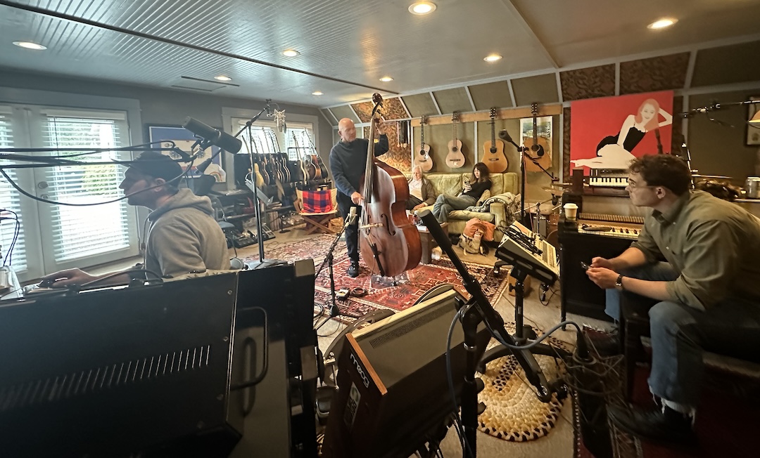 Dennis Crouch recording a part on May 8, 2024 at Daniel Tashian’s Royal Plum Studio. Crouch is seen playing his 1875-ish German upright, one of two he used on the album. At far left, Mike Stankiewicz, and, on the couch at rear, artist Molly Tuttle awaits her turn for recording a new part. Photo: Courtesy of Daniel Tashian.
