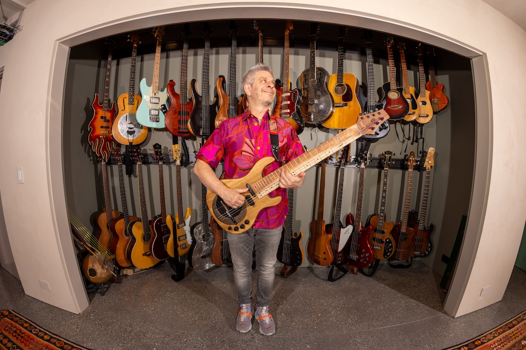 Mike Gordon, playing his (personally designed) prototype banjo-bass, a custom design by AndE Chase, in front of just a small sampling from his guitar collection. Photo: Shem Roose.