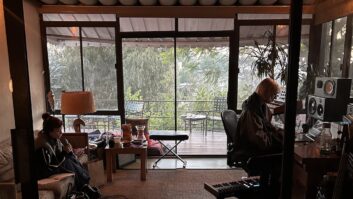 Lily Allen singing vocals from the couch, while producer Kito tracks her in the control room of Blue May’s home studio. Photo: Chloe Angelides