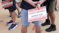 People wait outside of the Dallas Stadium holding signs reading World Cup tickets wanted during a FIFA World Cup game between the Netherlands and Japan, on Sunday, June 14, 2026 in Arlington. Photo: Shafkat Anowar/The Dallas Morning News via Getty Images.