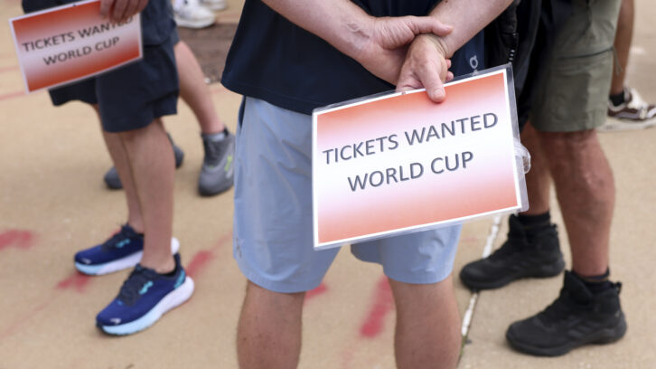 People wait outside of the Dallas Stadium holding signs reading World Cup tickets wanted during a FIFA World Cup game between the Netherlands and Japan, on Sunday, June 14, 2026 in Arlington. Photo: Shafkat Anowar/The Dallas Morning News via Getty Images.
