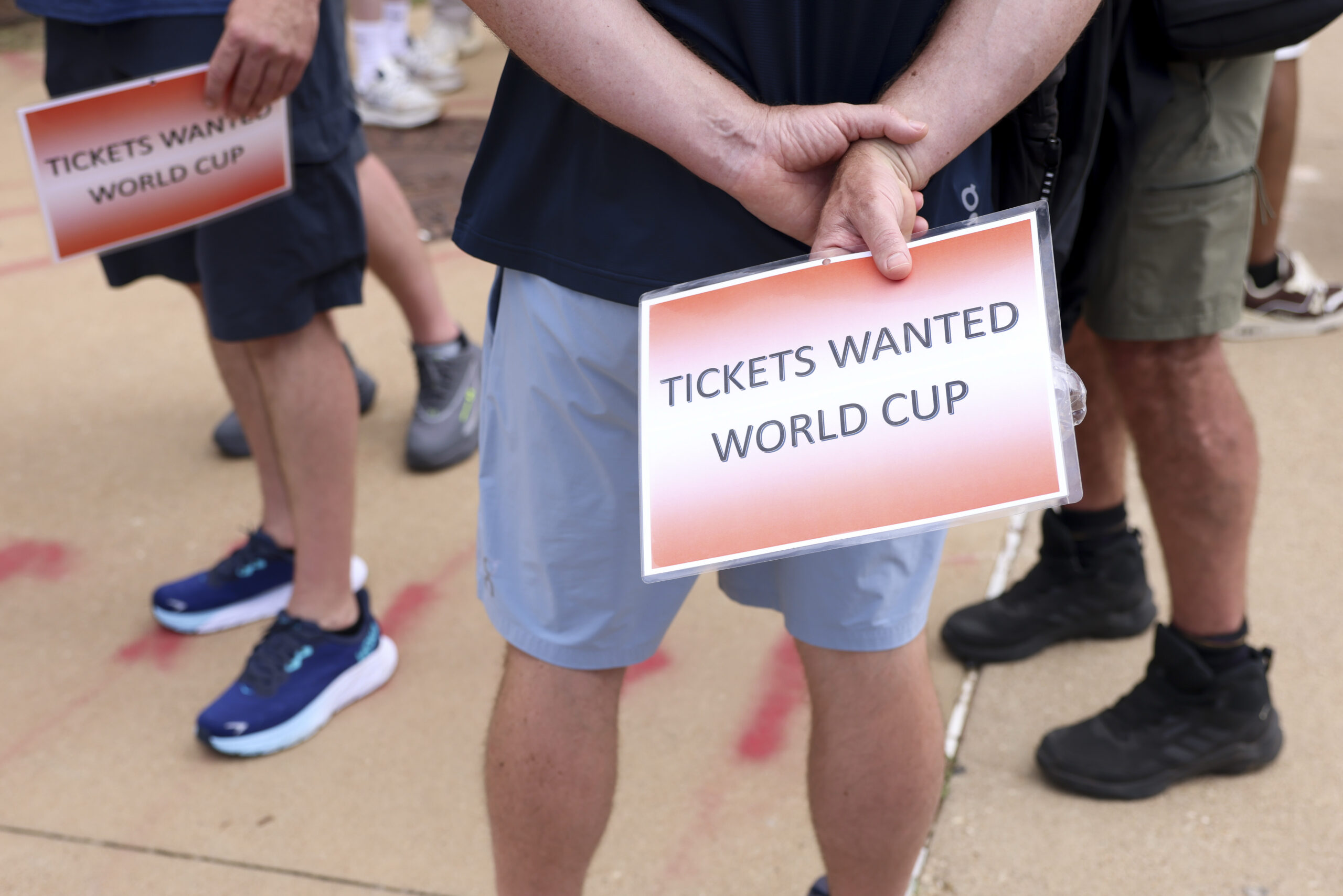 People wait outside of the Dallas Stadium holding signs reading World Cup tickets wanted during a FIFA World Cup game between the Netherlands and Japan, on Sunday, June 14, 2026 in Arlington. Photo: Shafkat Anowar/The Dallas Morning News via Getty Images.