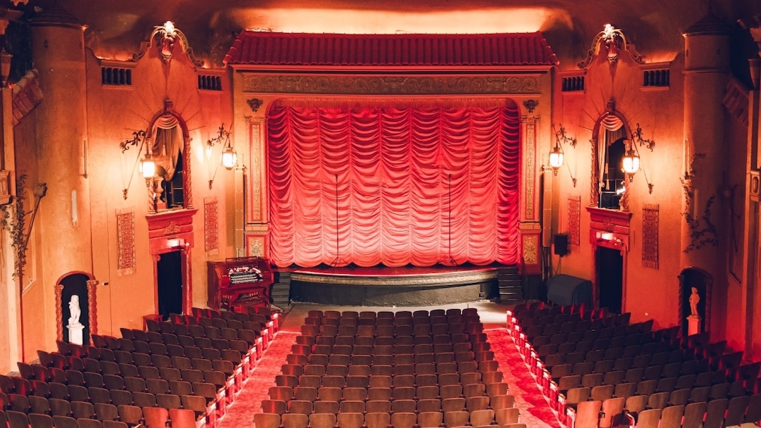 Alcons Audio speakers are discreetly placed on either side of the stage beneath the hanging lanterns.