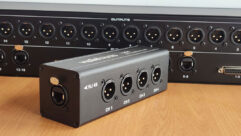 The Violet Audio io44 four-channel XLR-to-Ethercon adapter (foreground) and the DX16B 16-channel passive audio splitter.