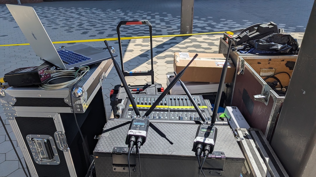 RF Venue’s RF PA Extension Kit, the receiver pair shown here atop the transmitter at the mix position during set-up, wirelessly delivered audio through the deployed receivers to powered speakers covering the graduate processional lineup at UMass Boston